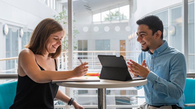 Two students talking at a desk