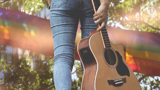 Denim-clad legs, a guitar, rainbow and greenery